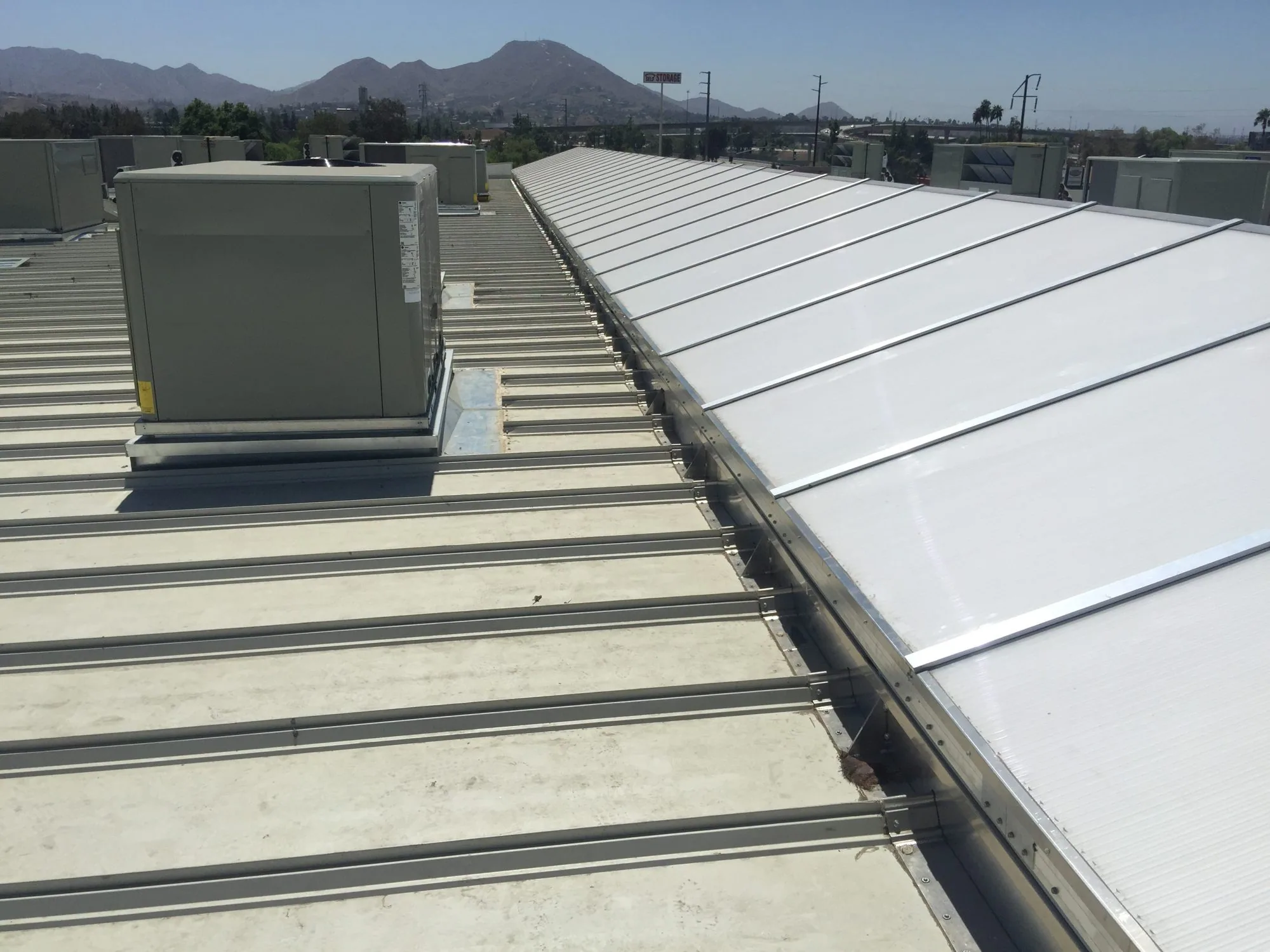 Curbs and skylights installed along a pitched standing-seam roof